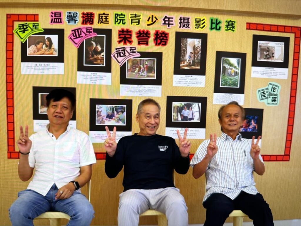 嵌宾在得奖作品荣誉榜前留影
