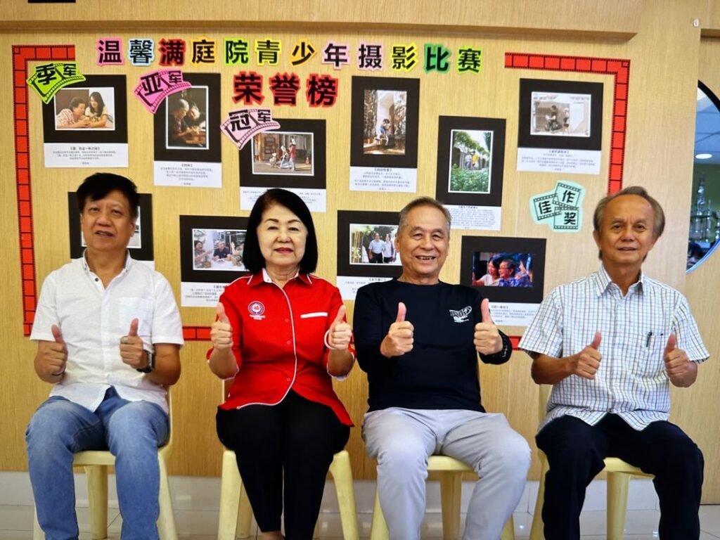 嵌宾在得奖作品荣誉榜前留影