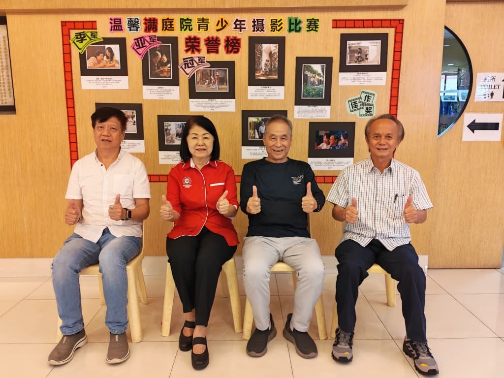 嵌宾在得奖作品荣誉榜前留影